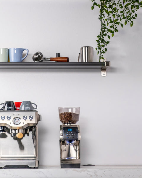 breville espresso machine next to a breville grinder on a kitchen counter