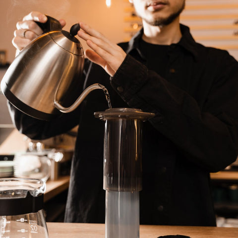 individual adding water brewiing with an aeropress