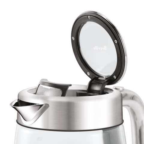 Silver and glass teapot with open lid on a white background