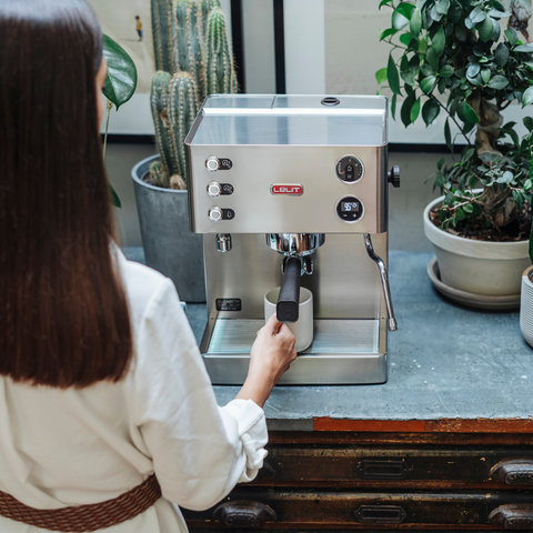 Person using a Lelit Elizabeth espresso machine with plants in the background