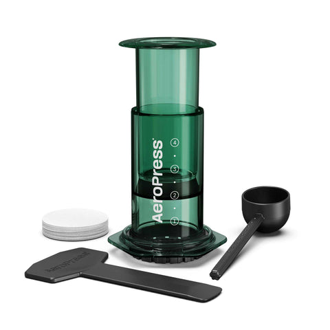 Green Aeropress coffee maker with components on a white background