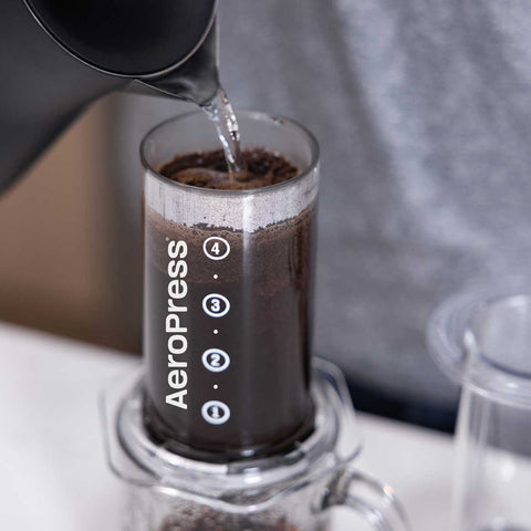 Aeropress coffee maker with coffee being poured into it