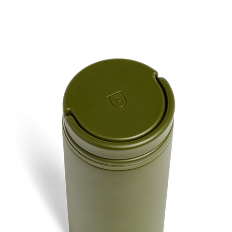 Green metal tumbler with a lid on a white background
