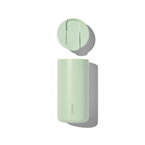 Light green tumbler with lid on a white background