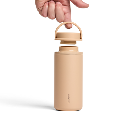 Beige thermos bottle with wooden lid on a white background