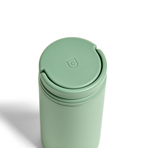Mint green travel mug with a lid on a white background
