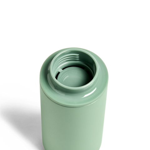 Green ceramic tumbler on a white background