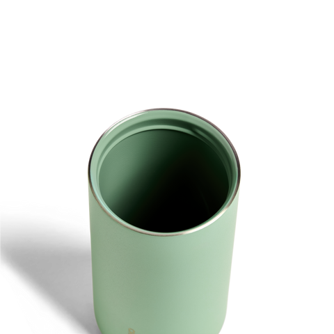 Green tumbler with a metallic rim on a white background