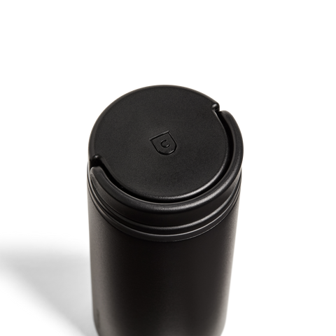 Black cylindrical container with a lid on a white background