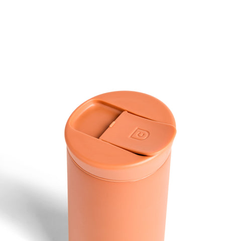 Orange travel mug with a lid on a white background