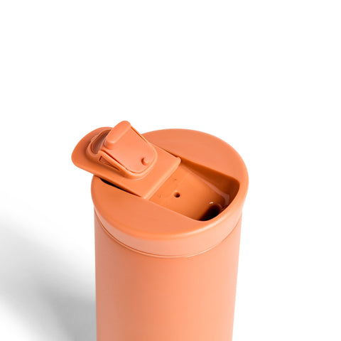Orange tumbler with a lid on a white background