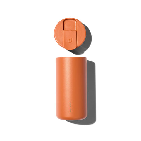 Orange travel mug with a lid on a white background