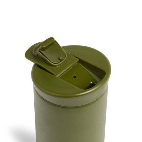 Green tumbler with a flip lid on a white background