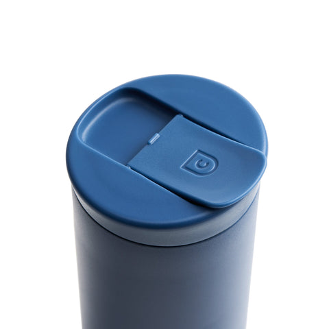 Blue tumbler with a lid on a white background