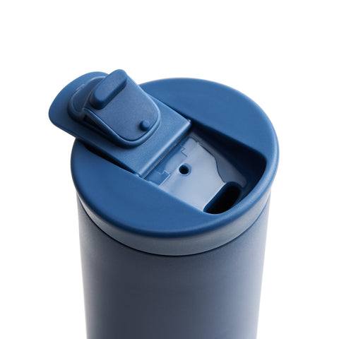Blue tumbler with a lid on a white background
