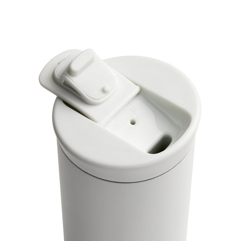 White ceramic tumbler with a lid on a white background