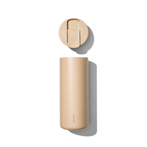 Beige water bottle with gold cap on a white background
