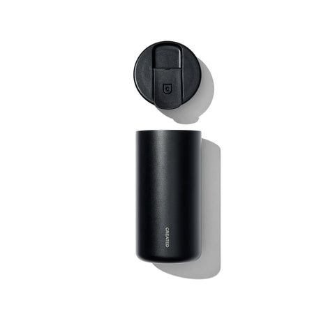 Black cylindrical container with a lid on a white background