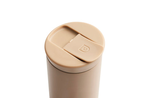 Beige tumbler with a lid on a white background