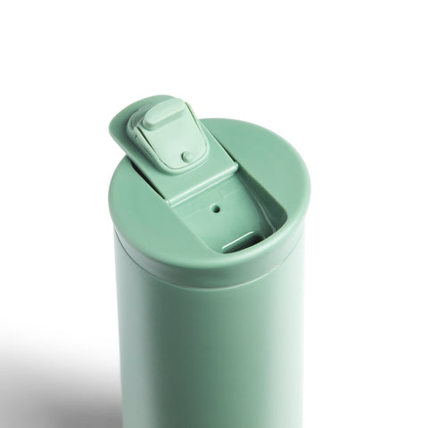Mint green tumbler with a lid on a white background