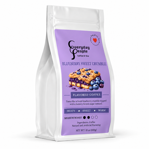 A 12 oz stand-up pouch of Everyday People Coffee & Tea Blueberry Sweet Crumble flavored coffee, featuring a white bag with a large purple label and an illustration of a blueberry crumble pie.