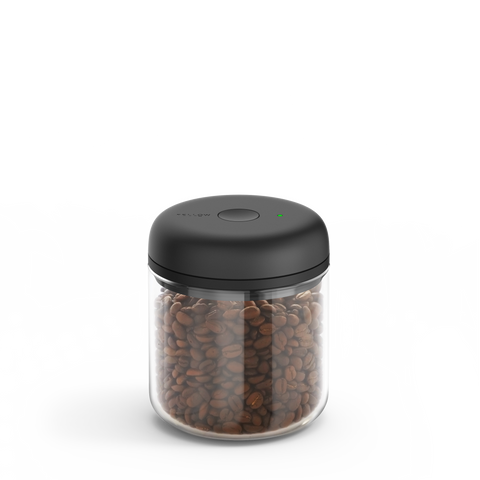 Fellow Atmos Vacuum Canister with black lid filled with coffee beans on a white background