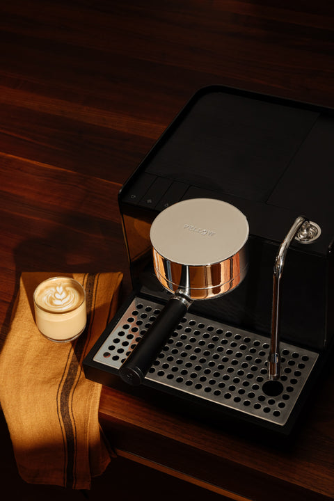Fellow Series 1 Espresso machine on a wooden surface with a candle in the background
