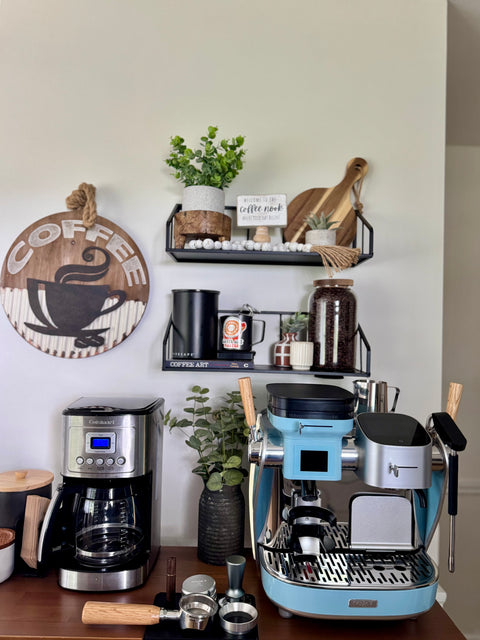 Coffee station with coffee maker, La Seine X espresso machine, and decorative items on a shelf.