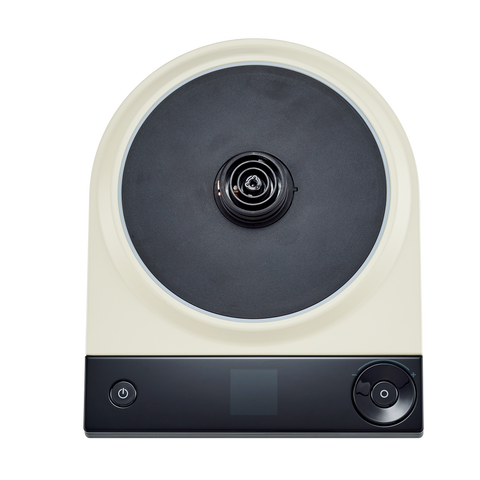 Round electronic device with a black center and beige rim on a white background