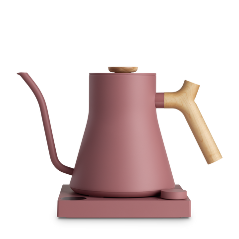 Pink kettle with wooden handle on a white background
