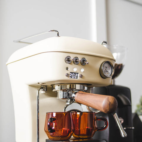 Ascaso Dream PID Automatic Home Espresso Machine - Sweet Cream with two amber glasses on a white background