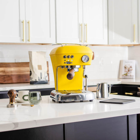 Ascaso Dream PID Automatic Home Espresso Machine - Sun Yellow a white countertop.