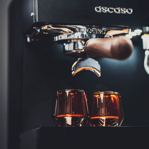 Ascaso Steel UNO Programmable Espresso Machine (Black) with two glasses of coffee below, featuring the Gaggia brand.