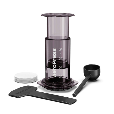 Aeropress coffee maker with components on a white background