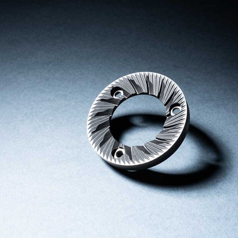 Silver ring with textured design on a gray background