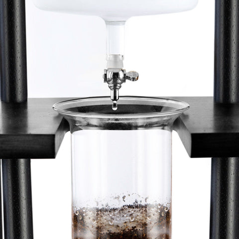 Yama 25 Cup Cold Brew Tower  Close-up of a glass coffee maker with water being poured into it.