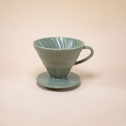 Hario V60 Ceramic Coffee Dripper 02 - Oil Green on a beige background