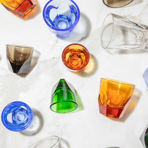 Colorful glass tumblers on a white surface
