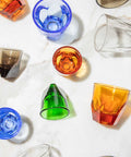Colorful glass tumblers on a white surface
